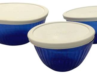 1233 - 3 Blue Pyrex Mixing Bowls w/ Lids (Description): Set of three cobalt blue ribbed glass mixing  bowls with fitted white plastic lids. The  bowls feature a vertical ribbed pattern and  graduated sizes, suitable for mixing,  storage, or serving. Each bowl comes with its own coordinating lid for convenient food  storage.