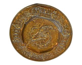 1175 - Copper Charger 16.5" (Description): A decorative copper charger measuring 16.5  inches in diameter. The piece features ornate  repousse work with elaborate scrolling  designs around the border and a central  medallion with detailed embossed imagery.