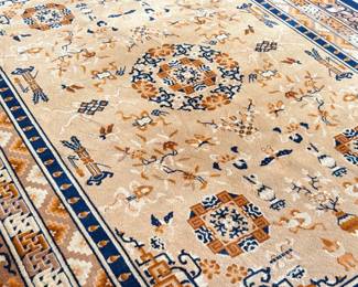 This lot features a Karastan Cathay Medallion area rug featuring a beige field and blue borders that measures, 120” H x 104” W.