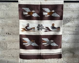 This lot features a Zapotec Indian handwoven wool rug featuring a stylized bird pattern. It is crafted in Oaxaca, Mexico, using traditional weaving techniques. This rug measures, 64” H x 29” W.