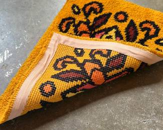 This lot features a latch hook tapestry created in the "rya style, " a shaggy textile technique that became a home decor staple in the 1960s and ’70s. This piece measures, 28” H x 20” W.