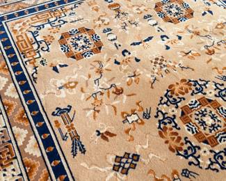 This lot features a Karastan Cathay Medallion area rug featuring a beige field and blue borders that measures, 120” H x 104” W.