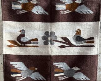This lot features a Zapotec Indian handwoven wool rug featuring a stylized bird pattern. It is crafted in Oaxaca, Mexico, using traditional weaving techniques. This rug measures, 64” H x 29” W.
