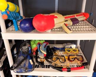 Shelves of water guns and snorkel swim gear with fins and goggles