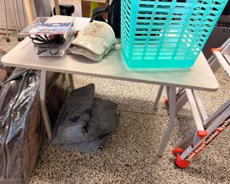 Folding table with baskets and fan, large stone underneath