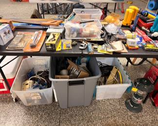 Table of assorted tools and hardware with bins of parts below