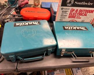 Makita power tools in cases with Black & Decker and electrical wire