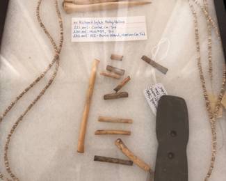 Native American shell bead necklaces and bone tools, framed display