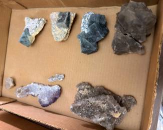 Box of raw mineral specimens and crystal clusters