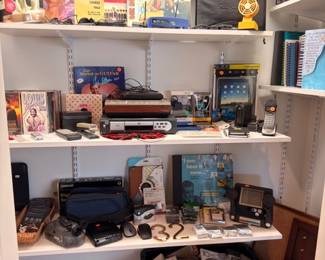 Closet shelves of vintage electronics, gadgets, cameras and media collectibles