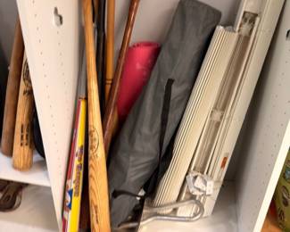 Vintage wooden baseball bats and folding table in closet