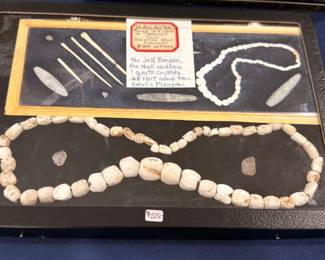 Native American shell bead necklace and bone tools, display case