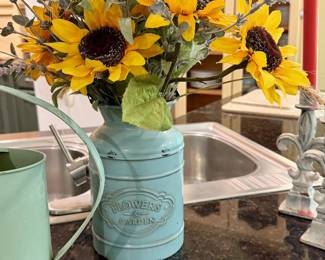 Metal watering cans with silk flowers.