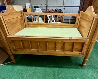 Antique crib with safety rail lowered.