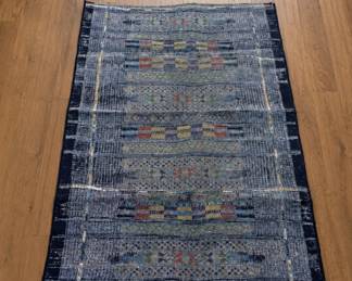 Small accent/entryway rug featuring a vintage-inspired global pattern with layered navy, charcoal, earthy neutrals, and muted multicolor detailing. Contemporary modern rug with versatile styling for entryways, offices, apartments, and layered living spaces.