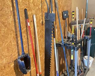 Antique crosscut saw, various shovels, pry bar, rakes, brooms, etc