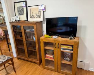 Gorgeous cabinet, has locking key too. Cabinet on left is 37" wide x 12" deep x 50.75" tall. Nona Hershey signed aquatint "Place Setting" and Benny Andrews signed lithograph "New York Cafe" Associated American Artists receipt 1974. Jewish cookbooks, Samsung 32" smart TV