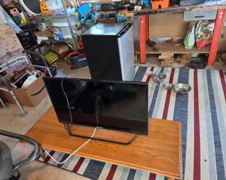tv, small fridge, floor matt, saw horses, garage stuff