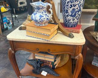marble topped vintage table, blue and white decorative pitcher, dragon blue and white vase, vintage books, black and brass candleticks