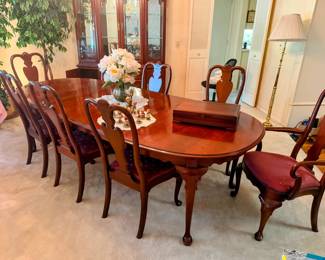 Picture your family at this beautiful Ethan Allen dining table with roomy seating for 8 for your next Thanksgiving dinner. The chairs are beautifully carved with red cushion seats and a protective table pad is included. Table is in excellent condition and pictured with 2 removable leaves.
