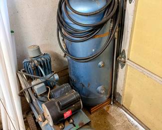 Large upright air compressor with hoses and gague. Heavy-duty garage/workshop equipment for air tools, tires, painting and general shop use.