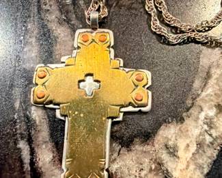 Decorative cross pendant necklace with ornate metalwork and chain. Eye-catching faith-inspired with a vintage look. 