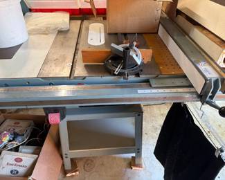 Large table saw/workshop saw set up with extended table, fence/guide rail, sturdy base, and other accessories included. Heavy-duty woodworking tool for garage, shop, or serious DIY users.