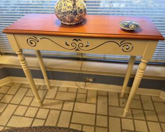 Decorative console table with wood top, painted base, turned legs and scrollwork detail Great accent piece for entryway, hallway, sunroom or behind a sofa. Pictured here in a kitchen bay window.