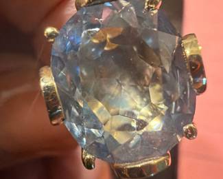 Large aquamarine-style statement ring with oversized faceted stone and decorative setting. 