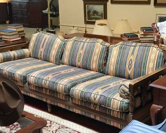 Wood frame sofa with southwest style patterned upholstery, carved arm details, and multiple back cushions. Stylish vintage seating piece for living room, den or sitting area. 