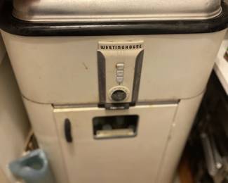features a vintage 1940s–1950s Westinghouse electric roaster oven mounted on its original matching white enameled steel rolling storage cabinet.
