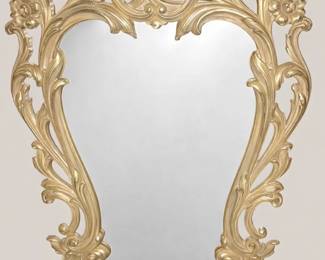Vintage Ornate Gold Wall Mirror Stunning vintage wall mirror featuring an elaborate baroque‑style gold frame with intricate scrollwork, floral motifs, and acanthus leaf detailing. The craftsmanship highlights graceful curves and a decorative crest at the top, giving the piece a regal, timeless presence. The mirror itself is clear and beautifully framed, perfect as a statement piece for an entryway, living room, or bedroom.