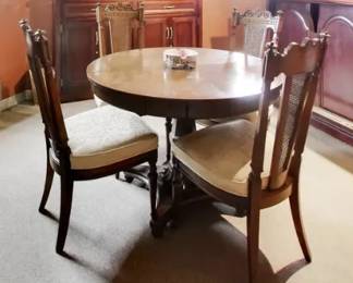 Round Wooden Dining Table with Four Carved Chairs Classic round wooden dining table paired with four matching chairs featuring beautifully carved backs and cushioned seats. The set has a warm, traditional look with solid construction and detailed craftsmanship throughout. Perfect for a kitchen, breakfast nook, or cozy dining area.  The table offers a comfortable seating arrangement for four, and the chairs provide supportive, upholstered seating with decorative woodwork that adds charm and character.  Includes:  Round wooden table  Four matching carved chairs with upholstered seats  Condition: