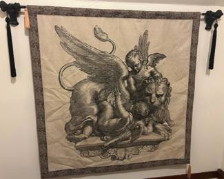 Black‑and‑White Mythological Tapestry Wall Hanging Striking black‑and‑white tapestry depicting a dramatic mythological scene featuring a winged lion with a human‑like face, accompanied by cherubic figures. The artwork is richly detailed, with expressive linework and classical symbolism that gives it a bold, museum‑style presence. The piece is framed with a patterned border and suspended from two decorative black hangers with tassels, adding an elegant finishing touch.  A captivating statement piece perfect for a hallway, study, or eclectic art collection.  Condition: Excellent; fabric, print, and hanging hardware all well maintained.