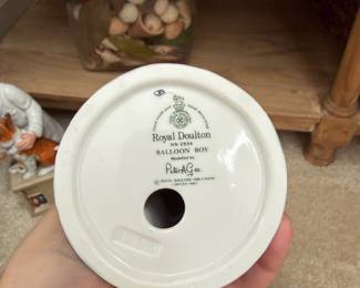 This is the base of the first balloon figurine β updating that description now! Base Markings β Royal Doulton "Balloon Boy" HN 2934 Maker: Royal Doulton, Made in England Figure Number: HN 2934 Title: "Balloon Boy" Modelled by: Peter A. Gee (signature visible) Copyright: Royal Doulton Tableware Limited, 1983 Mark: Crown and lion Royal Doulton backstamp with "Hand made and hand decorated" inscription