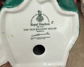 Base Markings β Royal Doulton "The Old Balloon Seller" HN 1315 Maker: Royal Doulton, Made in England Figure Number: HN 1315 Title: "The Old Balloon Seller" Modelled by: Leslie Harradine (signature visible) Copyright: Royal Doulton Tableware Limited, 1928 Mark: Crown and lion Royal Doulton backstamp with "Hand made and hand decorated" inscription