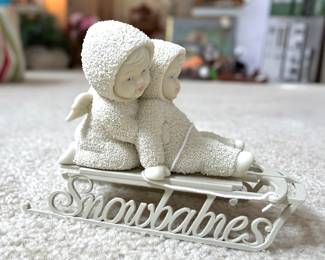 Item 13 β Department 56 Snowbabies "Sledding" Display Figurine A particularly lovely and displayable Snowbabies piece, featuring: Subject: Two Snowbabies sitting together on a decorative sled, one with small angel wings, both with the signature blue eyes and rosy cheeks Sled: A beautifully detailed metal/resin sled with ornate scrollwork and the word "Snowbabies" in elegant script lettering along the side β makes this a standout display piece Heart detail: Small heart accent visible on one baby's snowsuit Angel wings: One baby features delicate white angel wings Material: Bisque porcelain figures with granulated snow texture; decorative metal/resin sled base Finish: Crisp matte white throughout Condition: Appears excellent β beautiful, clean, no visible damage Size: Approximately 4β5" tall, 6β7" wide