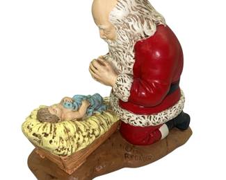 Kneeling Santa Claus Praying Over Jesus Figure
