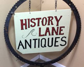 HISTORY LANE ANTIQUES 2 SIDED SIGN INSIDE A LARGE 30in ANTIQUE STEEL SAWMILL SPROCKET OR GEAR. ESTIMATE 40lbs NO SHIPPING PICK UP ONLY