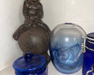 Dark metal figurine of child sitting on a ball