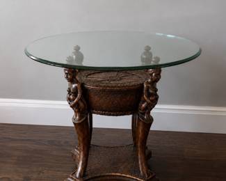 African Queen accent table with carved figures & glass top.