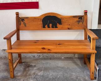 Wood carved bench with a bear