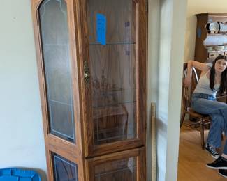 Tall oak curio cabinet with glass sides and shelves, great for display or dining room storage.