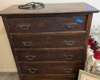 Dark wood five-drawer chest with brass-tone hardware and lots of vintage character.