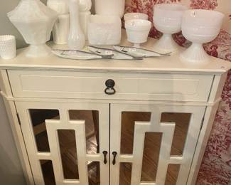 Corner cabinet with mirror front and assortment of milk glass