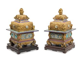 1046 A pair of Tibeto Chinese style gilt metal cloisonné and hardstone mounted censers Some Possible High Qing elements Possibly Mongolian, Late Qing Dynasty (1644-1912) or later Each gilt copper alloy censer with pierced lid, cast with dragon figural elements, including enameled panels and trimming depicting floral and geometric repeating patterns, accented by mounted glass and carved hardstone cabochons, raised on a carved wood stand atop an acrylic plinth 2 pieces Each: 23" H x 15" W x 15" D; Wood: 3.25" H x 14.75" W x 14.75" D; Acrylic: 12" H x 12" W x 16" D Estimate: $2,000 - $3,000