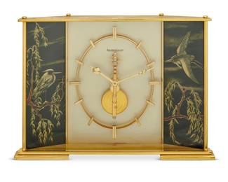1126 A Jaeger LeCoultre gilt brass table clock Circa 1965 Marked to glass front: JAEGER-LECOULTRE; impressed to underside: 366 / 2 With 8-day movement, glazed front, and opposed crane decorations 6.125" H x 8.25" W x 2.125" D Estimate: $600 - $800