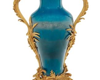 1077 A Louis XV style gilt bronze mounted porcelain vase Early 20th century, after the model by Theodore Millet (1853-1904) Bronze impressed: MB The Chinese-style blue ground baluster vase mounted with foliate-form handles and base with reed accents 24.75" H x 16.75" W x 10.75" D Estimate: $3,000 - $5,000