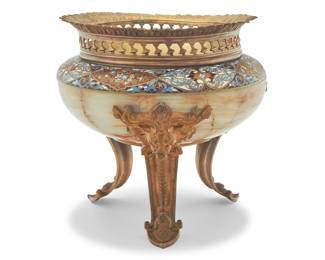1306 A French champlevé and gilt bronze mounted onyx centerpiece Circa 1870s With reticulated rim above a bronze interior, the onyx mounted with enameled foliate motifs, raised on lion's head mask chutes with pinecone feet and a central pinecone drop finial 11.25" H x 11.25" Dia. Estimate: $2,500 - $3,500
