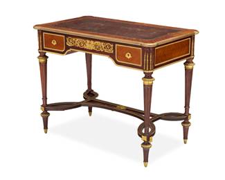 1083 A Louis XVI style mahogany table Late 19th/early 20th century The gilt-tooled leather top above two locking side drawers and a central spring-loaded drawer, overall mounted with gilt-bronze foliate motifs, raised on fluted tapered legs joined by a ribbon-form stretcher 29.75" H x 37.75" W x 22.25" D Estimate: $2,000 - $3,000